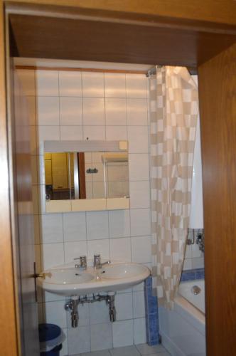 a bathroom with a sink and a mirror and a tub at Ski and Lake View Apartment in Zell am See