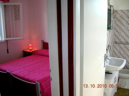 a bedroom with a pink bed and a sink at Atticogrado in Lido