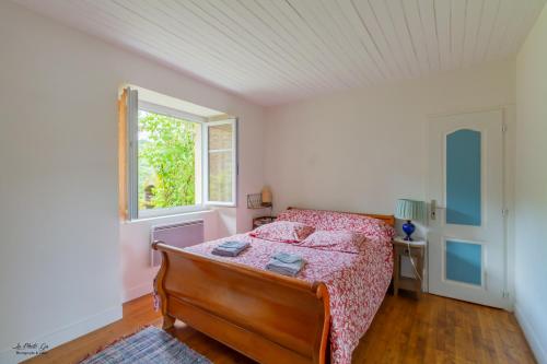 een slaapkamer met een bed en een raam bij Gite Des Croix Bancaud in Jumilhac-le-Grand
