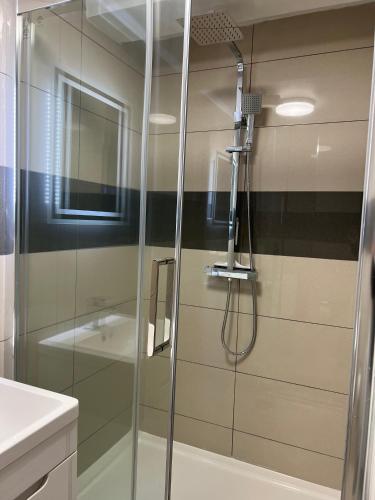 a shower with a glass door in a bathroom at Lovely holiday home in Southminster in Southminster