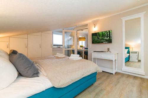 Schlafzimmer mit einem Bett, einem Schreibtisch und einem TV in der Unterkunft Villa Albertine, App. 10 in Ahlbeck