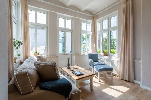 ein Wohnzimmer mit einem Sofa und einem Tisch in der Unterkunft Villa Albertine, App. 02 in Ahlbeck