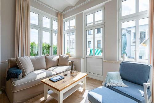 ein Wohnzimmer mit einem Sofa und einem Tisch in der Unterkunft Villa Albertine, App. 02 in Ahlbeck