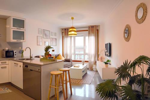 cocina y sala de estar con encimera y taburetes en Apartamento Rosalía, en A Illa de Arousa