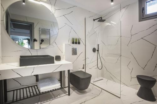 y baño con ducha, lavabo y espejo. en Villa Royal, en Kaligata