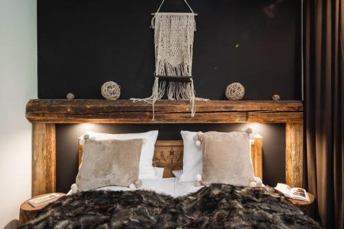 a bedroom with a bed with a wooden head board at Aparthotel Delta Royal in Kościelisko