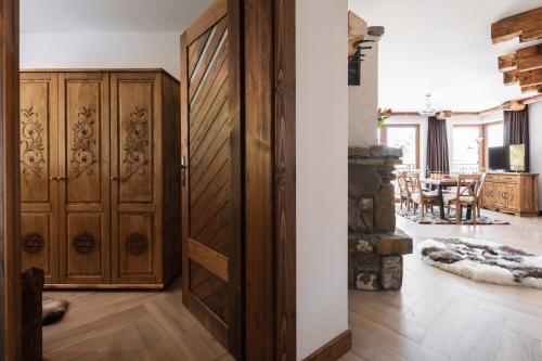 a room with a wooden door and a dining room at Aparthotel Delta Royal in Kościelisko