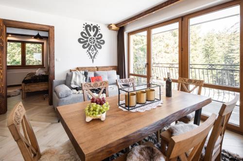 a dining room with a wooden table with fruit on it at Aparthotel Delta Royal in Kościelisko
