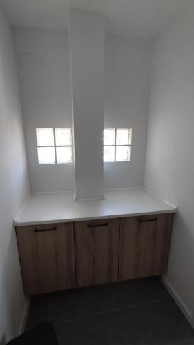 a kitchen with two windows and a white counter top at Casa Valparaíso in San Martín de Laspra