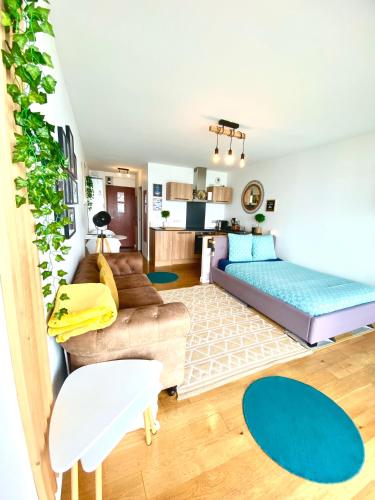 a living room with a bed and a couch at - L'IROIZH - CONCARNEAU - VUE MER PANORAMIQUE - STUDIO STANDING PLAGE DES SABLES BLANCS - PARKING - DRAPS & SERVIETTES INCLUS - NEAR THALASSOTHERAPY - Wifi - in Concarneau