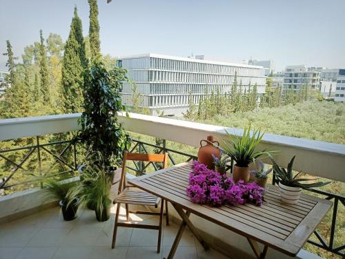 un balcone con tavolo in legno e piante di CASA MYRlAM Marousi -View & Private Parking- ad Atene