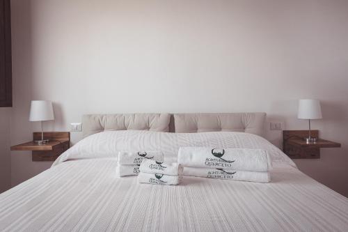 a white bed with three towels on it at Agriturismo Querceto in Frazione Mocaiana