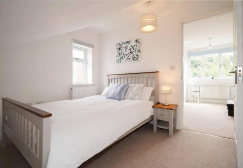ein weißes Schlafzimmer mit einem großen weißen Bett und zwei Fenstern in der Unterkunft Luxury Spa Home With Hot Tub Sauna And Pool Table in Chesterfield