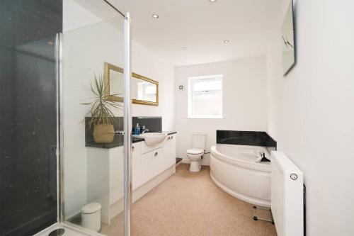 a bathroom with a tub and a sink and a toilet at Luxury Spa Home With Hot Tub Sauna And Pool Table in Chesterfield