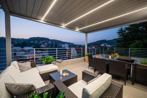 a patio with couches and tables on a balcony at Apartmány Kaskády Luhačovice in Luhačovice