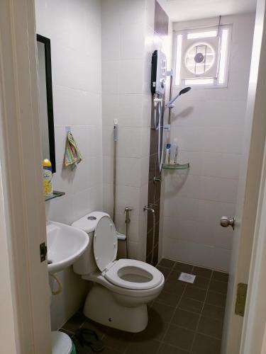 a bathroom with a white toilet and a sink at Sekinchan HighLevel SeaView Homestay 高楼 看海 阳台民宿 in Sekincan