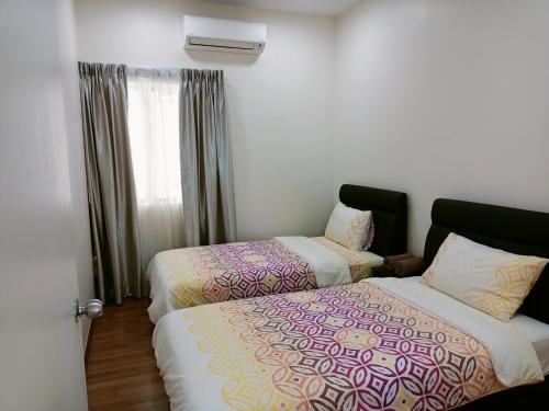 two beds in a room with a window at Sekinchan HighLevel SeaView Homestay 高楼 看海 阳台民宿 in Sekincan