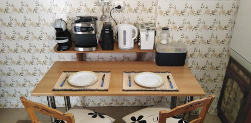 uma pequena mesa com dois pratos e uma cafeteira em Ομορφο διαμερισμα με μεγαλες βεραντες em Atenas