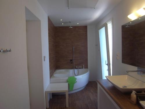 ein Badezimmer mit einer weißen Badewanne und einem Waschbecken in der Unterkunft Villa Naousa in Naoussa