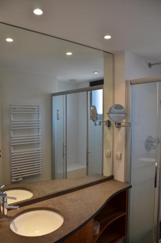 une salle de bain avec deux lavabos et un grand miroir dans l'établissement Lac paradisiaque, à Duingt