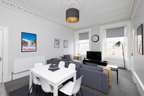 a living room with a couch and a table at JOIVY Splendid 4-bed Flat Near The Castle in Edinburgh