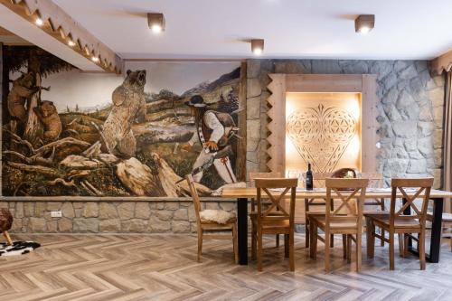 a dining room with a large painting on the wall at Aparthotel Delta Royal in Kościelisko