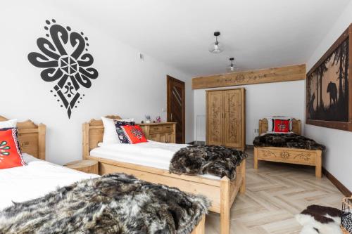 a bedroom with two beds and two chairs at Aparthotel Delta Royal in Kościelisko