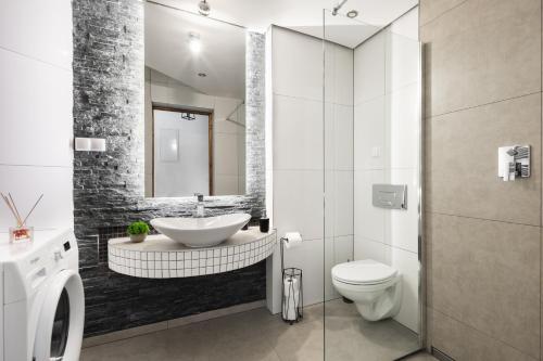 a bathroom with a sink and a toilet at Aparthotel Delta Royal in Kościelisko