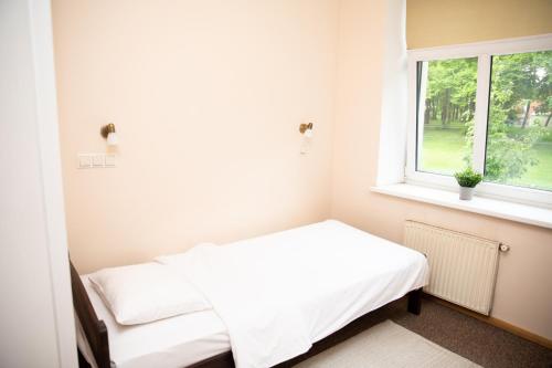 a small bedroom with a bed and a window at Avitar in Rīga