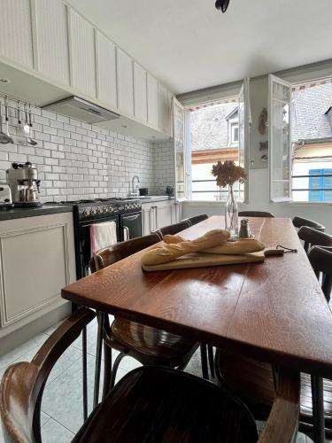 une cuisine avec une table en bois et quelques chaises dans l'établissement Honfleur house, à Honfleur