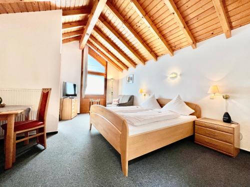 a bedroom with a bed and a desk and a table at Weinhaus am Schieferfels in Veldenz