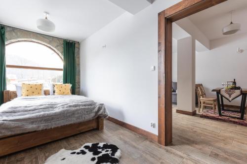 a bedroom with a bed and a large window at Aparthotel Delta Royal in Kościelisko