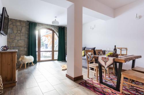 a kitchen and dining room with a table and chairs at Aparthotel Delta Royal in Kościelisko