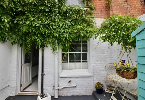 a white house with a window and a tree at West Street Retreat Grade II listed townhouse in Harwich