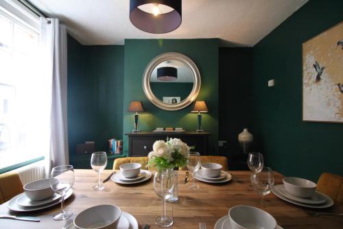 a dining room with a table and a mirror at West Street Retreat Grade II listed townhouse in Harwich