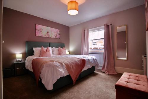 um quarto com uma cama grande e uma janela em West Street Retreat Grade II listed townhouse em Harwich