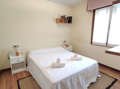1 dormitorio con 1 cama con 2 toallas en LA PLAYA DE TOÑA by Urdaibai Rentals, en Pedernales