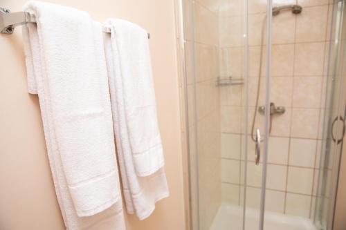 a bathroom with white towels and a shower at Avitar in Rīga