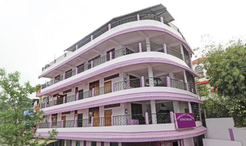 wysoki fioletowy budynek z balkonami i drzewami w obiekcie Itsy By Treebo - Shillong Tower Guesthouse w mieście Shillong