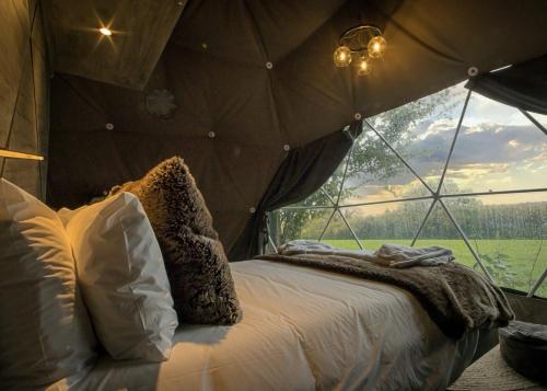 a room with a bed in a tent with a window at Finest Retreats - Hever Luxury Dome 
