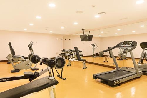 a gym with several treadmills and exercise bikes at CM Mallorca Palace - Only Adults in Sa Coma