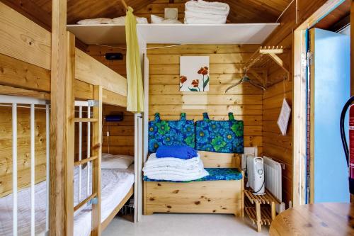 a bedroom with bunk beds in a wooden cabin at Simple little cottage in a cozy courtyard in Vimmerby in Vimmerby