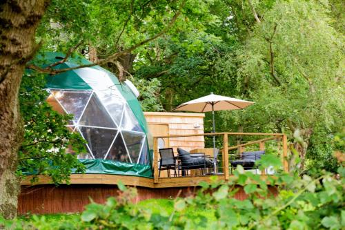 a gazebo with chairs and an umbrella on a deck at Finest Retreats - Chartwell Luxury Dome 