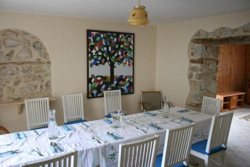 a dining room with a table with chairs and a painting at Hangjik (Little Inn) 