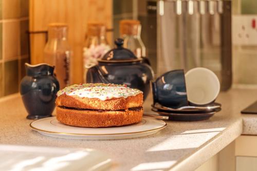 a cake on a plate on a kitchen counter at Potters Brook in Framlingham