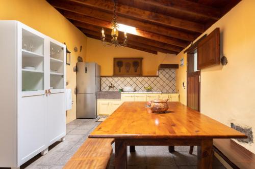 a kitchen with a wooden table and a refrigerator at Casa el Nogal in La Orotava