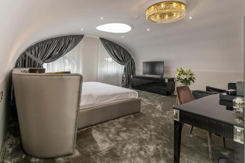 een slaapkamer met een bed, een bureau en een televisie bij St Palace Hotel in Vilnius