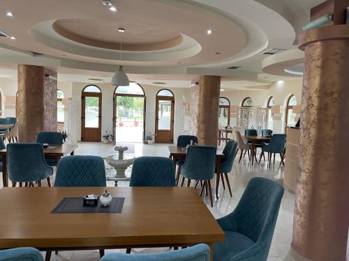 a dining room with tables and chairs and columns at Hotel5E in Plav