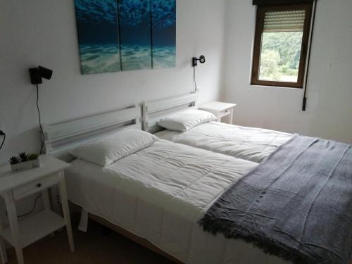 1 dormitorio con cama, mesa y ventana en Apartamentos Trevias, en Trevías