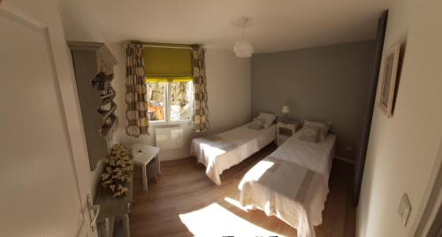 - une petite chambre avec 2 lits et une fenêtre dans l'établissement Adorable maison d’hôtes bordée d’étangs au calme., à Grandcourt